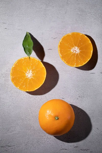 fresh orange and yellow slices of oranges on a gray background. top view.