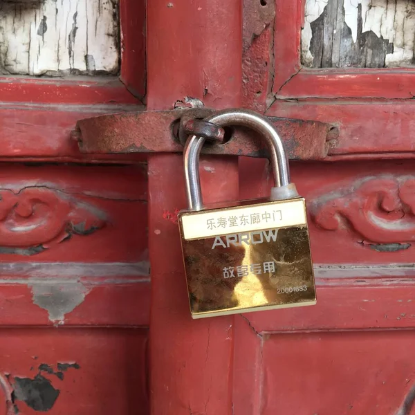 old rusty padlock on the background of the red door