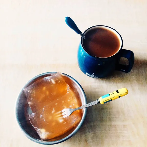 a cup of tea with a spoon and a teaspoon