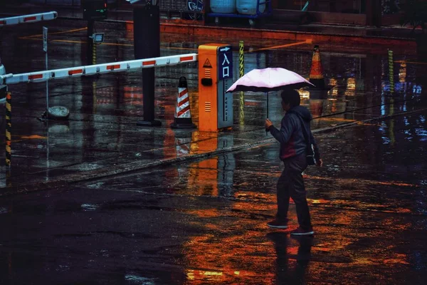man in a raincoat walking in the city