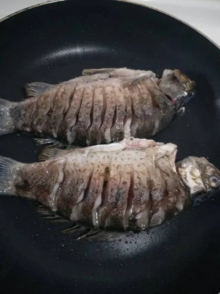 raw fish on a frying pan