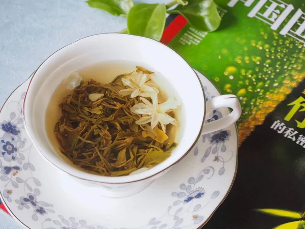 herbal tea with green leaves and a cup of hot drink