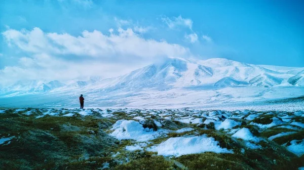 man in a jacket with a backpack on the mountain