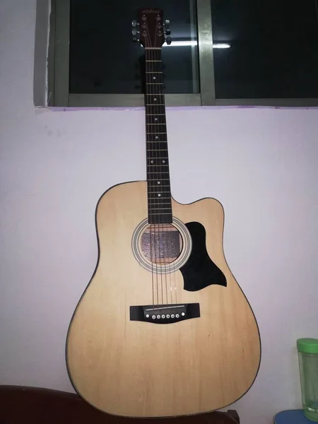 acoustic guitar on the background of a wooden wall