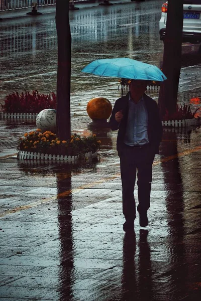 a man in a raincoat with a umbrella on the background of the river