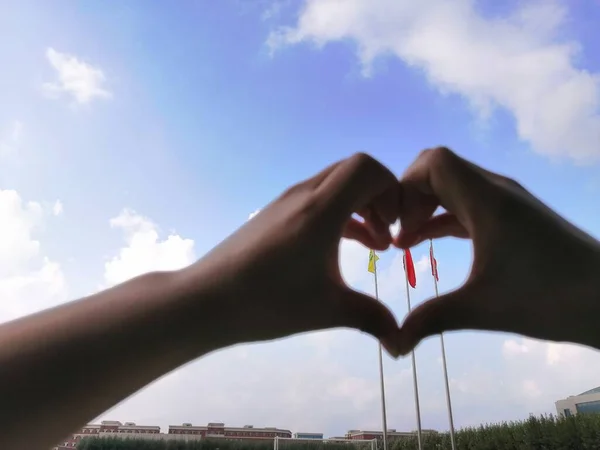 heart in hand on sky background