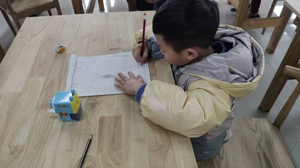 boy draws a pencil on the floor