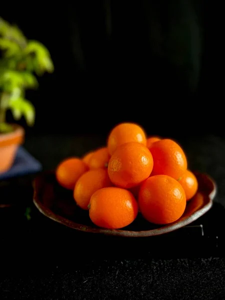 fresh orange and black and white fruits on a dark background