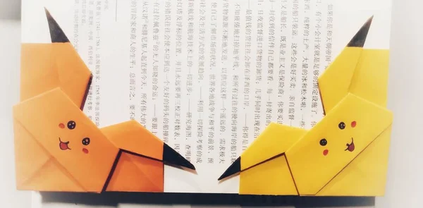 a set of different types of paper with yellow and white pencils on a light background.