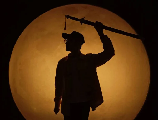 silhouette of a man with a sword on a black background