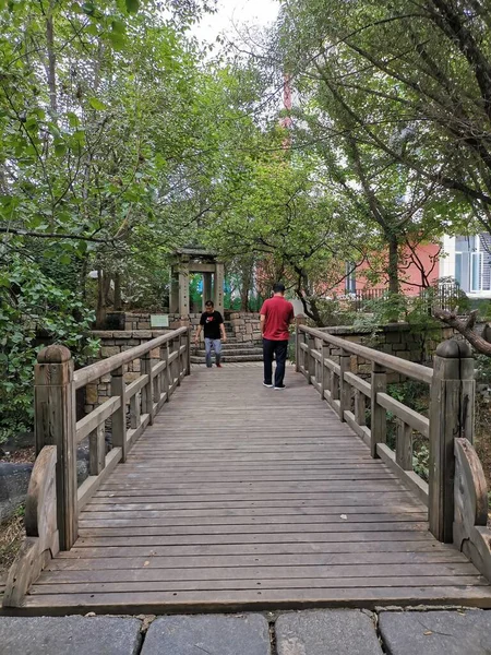 a man in a red dress is walking along the path