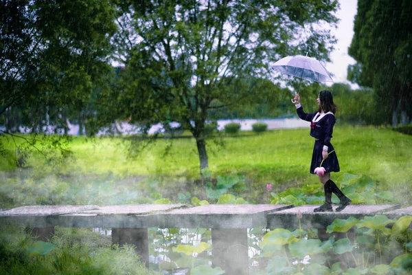 young woman in a rain dress with umbrella