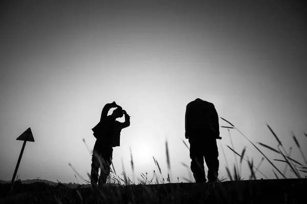 silhouette of a man and woman on the background of the sunset