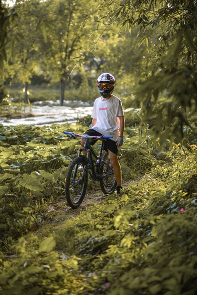 young man riding bicycle in the forest