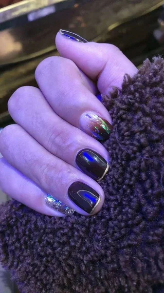 female hands with a nail polish on a wooden background