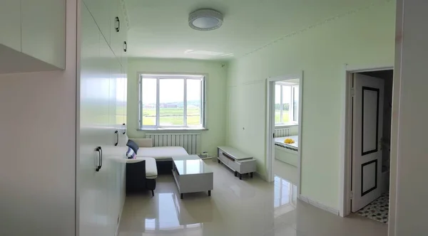 interior of a hospital room with a white walls and a large window
