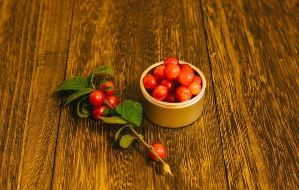 cherry tomatoes with leaves on wooden background