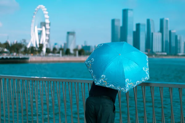 young woman with umbrella and rain drops on the background of the sea