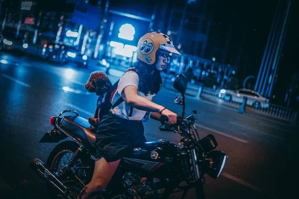 young woman with motorcycle in the night
