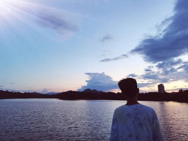 silhouette of a man in a blue dress on the lake