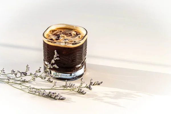 glass of milk with ice cream and cinnamon on a white background