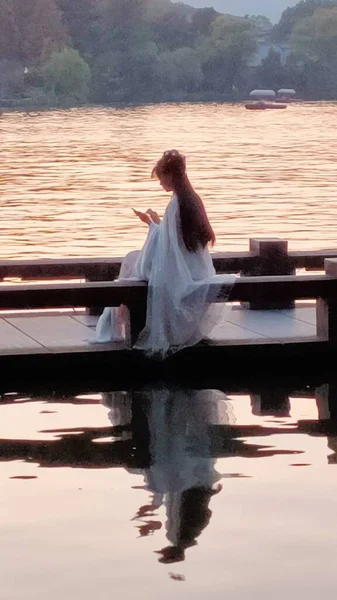 beautiful young woman in a white dress with a boat
