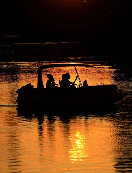 silhouette of a man in a boat on the river