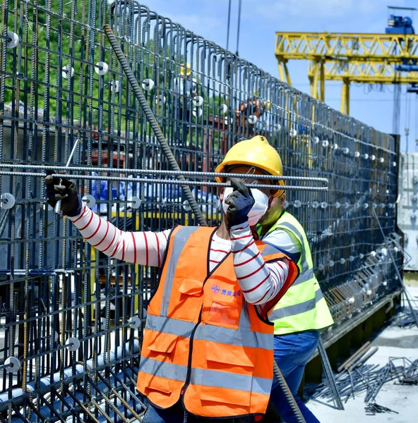 worker in protective suit and helmet with a crane