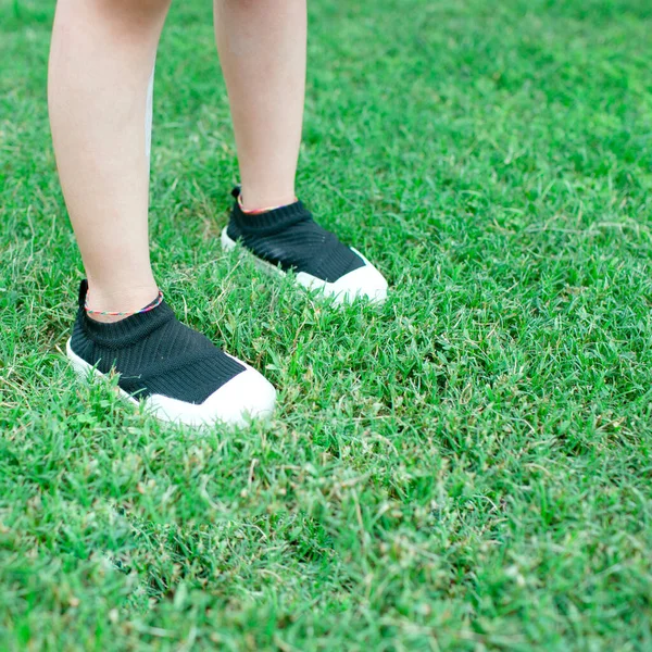 feet of a woman lying on green grass