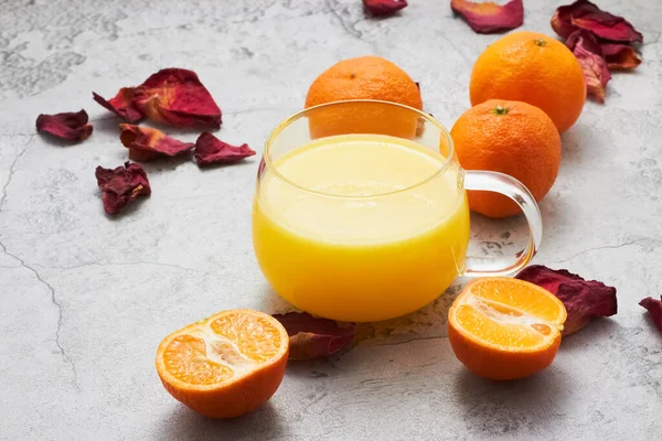 orange juice and oranges on a white background