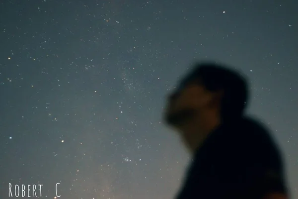 silhouette of a man in a suit on a background of a night sky