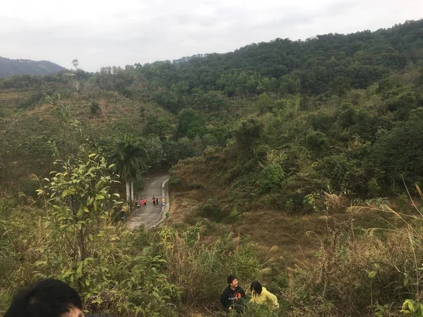 a man in a green dress with a backpack on the road