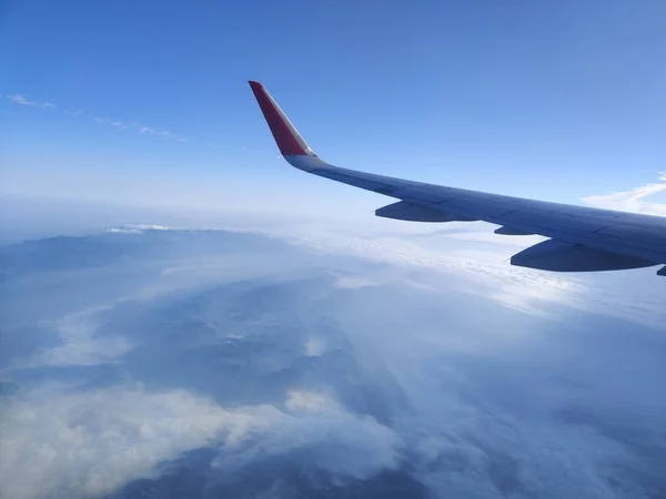view of the wing of a plane in the sky