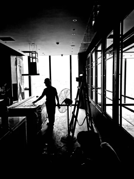 black and white photo of a man in a suit with a house