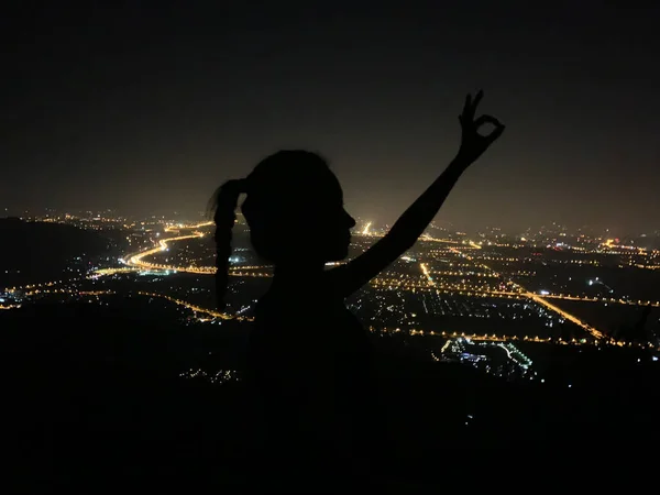 silhouette of a woman with a black dress on the background of the night sky