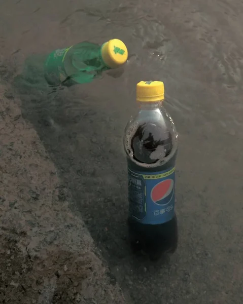 a small bottle of water in the puddle