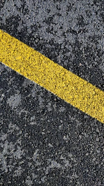 yellow asphalt road with white stripes