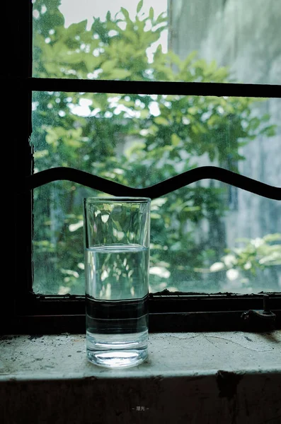 glass of water in a transparent jug on a background of a window