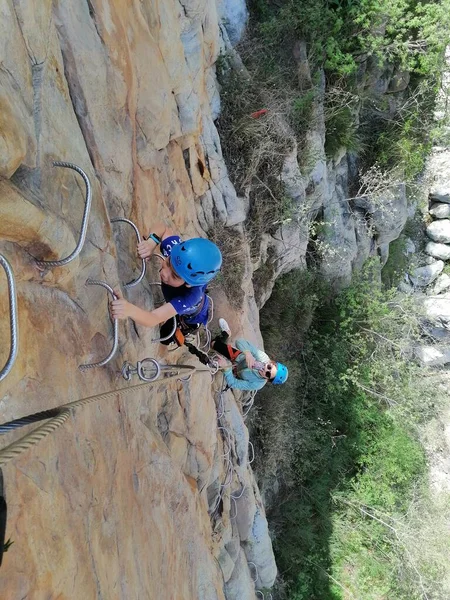 a man climbs a cliff in the mountains