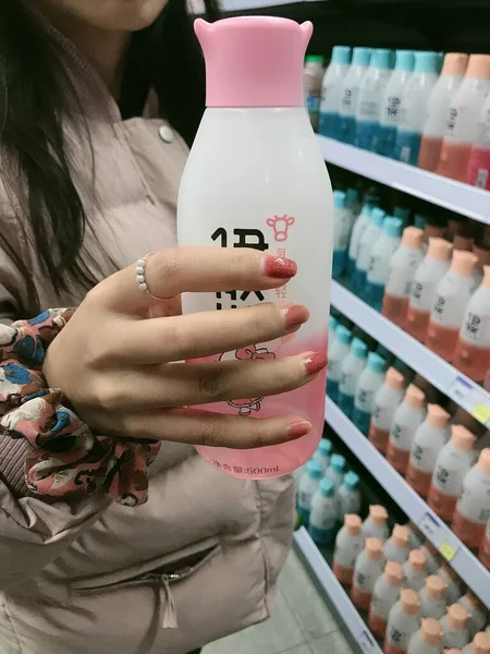 woman holding a bottle of milk in the store