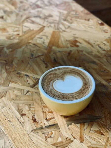 cup of coffee with a heart on a wooden background