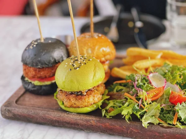 delicious burger with meat and vegetables on wooden table