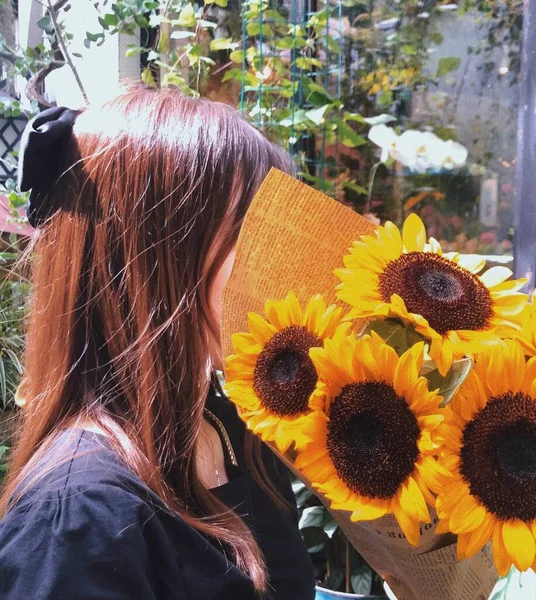 beautiful young woman with sunflower in the field