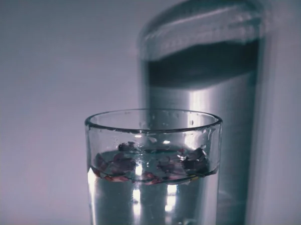 glass of water with a white liquid on a dark background