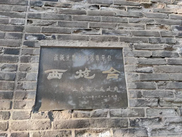 old stone wall with a sign of the ancient city