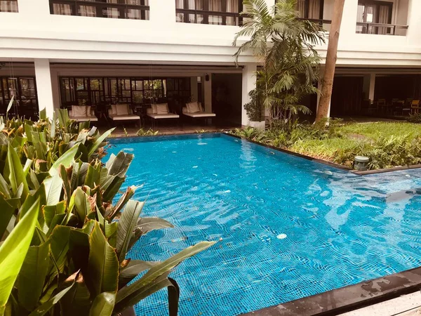 beautiful luxury swimming pool with green water and a blue sky