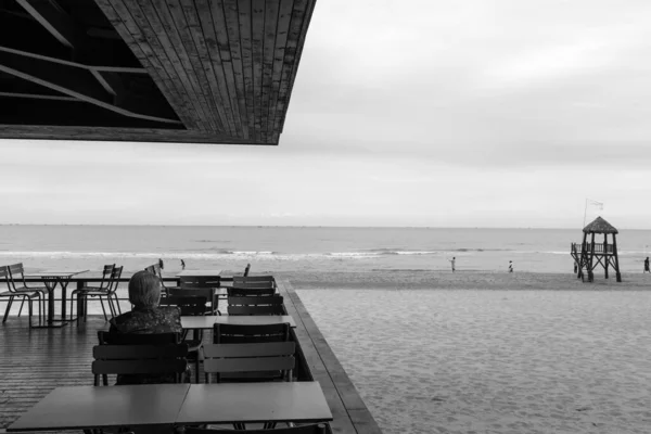 black and white photo of a pier in the sea