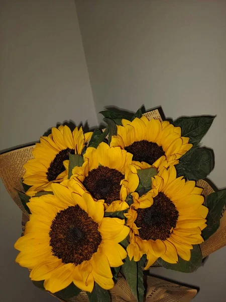 beautiful sunflowers in a vase on a background of a wooden table