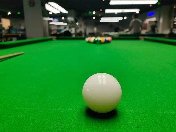 billiard table with cue and pool ball