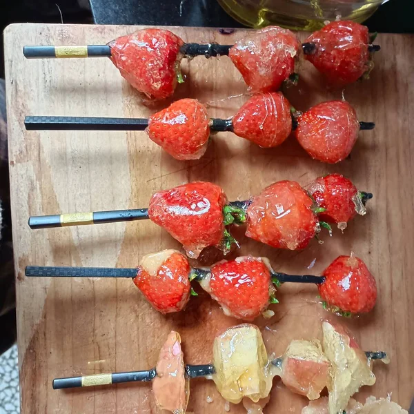 fresh strawberries and cherry tomatoes on a wooden board